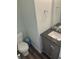 Cozy half bath with a modern vanity, gray cabinet, granite counter and neutral paint at 6824 W Philadelphia Dr, McCordsville, IN 46055