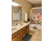 Bright bathroom featuring a double sink vanity, a floral shower curtain, and neutral-toned tile flooring at 6824 W Philadelphia Dr, McCordsville, IN 46055