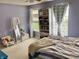 Bedroom showcasing a window with curtains, a bookshelf filled with books and toys, and carpeted flooring at 6824 W Philadelphia Dr, McCordsville, IN 46055