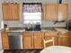 The Kitchen features wooden cabinets, stainless steel appliances, and a sink under a window at 6824 W Philadelphia Dr, McCordsville, IN 46055