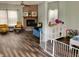 Open concept living area featuring a fireplace, hardwood floors, a ceiling fan, and a safety gate at 6824 W Philadelphia Dr, McCordsville, IN 46055