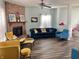 Bright living room featuring a fireplace, ceiling fan, hardwood floors, and comfortable seating arrangements at 6824 W Philadelphia Dr, McCordsville, IN 46055