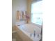 Bright bathroom features a soaking tub next to a glass door shower under a window at 6924 Havenmoor Pl, Indianapolis, IN 46250