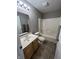 Neutral colored bathroom with tile floors, wood vanity, and shower-tub combo at 6924 Havenmoor Pl, Indianapolis, IN 46250