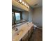 Bright bathroom features a double sink vanity, a large mirror, and a garden tub under a window at 6924 Havenmoor Pl, Indianapolis, IN 46250
