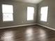 Bright bedroom featuring three windows, new paint, and hardwood floors at 6924 Havenmoor Pl, Indianapolis, IN 46250