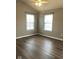 Bright bedroom featuring two windows, a ceiling fan, new paint, and hardwood floors at 6924 Havenmoor Pl, Indianapolis, IN 46250