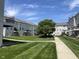 Exterior view of the Townhouse, with well-manicured lawns, landscaping, and a sidewalk at 6924 Havenmoor Pl, Indianapolis, IN 46250