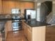 Kitchen with a center island, stainless steel appliances, and wood cabinets and floors at 6924 Havenmoor Pl, Indianapolis, IN 46250