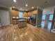 Bright kitchen with wood floors, an island, stainless steel appliances, and tan cabinetry at 6924 Havenmoor Pl, Indianapolis, IN 46250