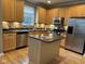 Bright kitchen with island, stainless steel appliances, and wood cabinets and floors at 6924 Havenmoor Pl, Indianapolis, IN 46250