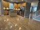 Bright kitchen featuring a center island, wood floors, stainless steel appliances, and tan cabinetry at 6924 Havenmoor Pl, Indianapolis, IN 46250