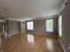 Spacious living room featuring hardwood floors, crown molding, and bright windows at 6924 Havenmoor Pl, Indianapolis, IN 46250