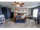 Large bedroom with neutral carpet, four-poster bed, a ceiling fan, and dark blue accent wall at 7320 Corwin Ct, Indianapolis, IN 46259