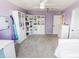 Spacious bedroom with carpet, purple walls, ceiling fan, and white shelving at 7320 Corwin Ct, Indianapolis, IN 46259