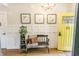 Bright foyer with wainscoting, decorative art, and a stylish bench and plant stand next to a yellow door at 7320 Corwin Ct, Indianapolis, IN 46259