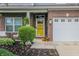 Inviting front entrance with a yellow door, brick accents, and charming landscaping, offering curb appeal at 7320 Corwin Ct, Indianapolis, IN 46259