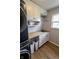 Laundry room showcases a stacked washer and dryer, white cabinets and a sink area at 7320 Corwin Ct, Indianapolis, IN 46259