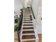 Beautiful staircase with wood treads, white risers, wrought iron railing and decor at 7320 Corwin Ct, Indianapolis, IN 46259