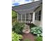 Backyard featuring a striped awning, gravel walkway, Adirondack chairs, and lush landscaping at 8130 Winterset Cir, Indianapolis, IN 46214