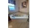 Bright bathroom showcasing an oval jetted tub with a modern faucet and neutral toned walls at 8130 Winterset Cir, Indianapolis, IN 46214