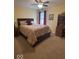 Cozy bedroom featuring a comfortable bed with a patterned coverlet, and a vintage-style desk at 8130 Winterset Cir, Indianapolis, IN 46214