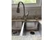 Close up of a stainless steel kitchen sink with modern faucet and granite countertops at 8130 Winterset Cir, Indianapolis, IN 46214