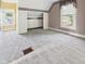 Attic bedroom with window, closet, floral and striped wallpaper and neutral carpeting at 814 Walnut St, Anderson, IN 46012