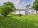 Spacious backyard with lush green grass and a detached garage, framed by mature trees at 814 Walnut St, Anderson, IN 46012