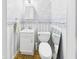 Bathroom featuring a toilet, vanity, and blue-striped wallpaper at 814 Walnut St, Anderson, IN 46012