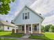 Inviting two-story home boasting stone accents, a covered porch, and an American flag at 814 Walnut St, Anderson, IN 46012