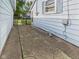 Exterior side view with a patterned walkway leading to a side door, complemented by decorative garden statuettes at 814 Walnut St, Anderson, IN 46012