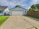 Detached garage with a white garage door and extended driveway, providing ample parking space at 814 Walnut St, Anderson, IN 46012