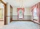 Charming living room with a chandelier and vintage-inspired wallpaper and trim at 814 Walnut St, Anderson, IN 46012