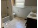 Traditional bathroom featuring a tub with shower, neutral paint, and double vanity sinks under a window at 825 W Auman Dr, Carmel, IN 46032