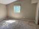 Empty bedroom with neutral walls, worn carpet, and a bright window at 825 W Auman Dr, Carmel, IN 46032
