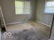 Empty bedroom with worn carpet and two bright windows at 825 W Auman Dr, Carmel, IN 46032