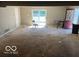 Empty living room with sliding doors, a red door and worn carpet at 825 W Auman Dr, Carmel, IN 46032