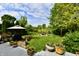 Landscaped backyard with patio, grill, and lush greenery, ideal for outdoor enjoyment at 938 Weeping Way Ln, Avon, IN 46123