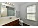 Bright bathroom featuring a wood vanity, large mirror, and a patterned shower curtain at 938 Weeping Way Ln, Avon, IN 46123