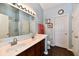 Bathroom featuring double sinks, hardwood flooring, a large mirror, and bright lighting at 938 Weeping Way Ln, Avon, IN 46123