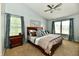 Bedroom featuring a ceiling fan, two windows, carpet floors, and a wooden framed bed with grey bedding at 938 Weeping Way Ln, Avon, IN 46123