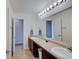 Bright bathroom featuring double sinks, modern lighting, and neutral tile flooring at 951 Gondola Run, Greenfield, IN 46140