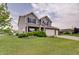 Beautiful home with lush green lawn, mature trees and shrubs, and a two-car attached garage at 951 Gondola Run, Greenfield, IN 46140