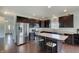 Modern kitchen with stainless steel appliances, dark wood cabinets, an island, and hardwood floors at 951 Gondola Run, Greenfield, IN 46140