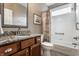 A lovely bathroom with granite countertops, wood cabinets, and a shower-tub with a decorative curtain at 1020 Lair Ct, Westfield, IN 46074