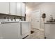 A practical laundry room featuring a front-load washer and dryer, granite countertops, and ample cabinet space at 1020 Lair Ct, Westfield, IN 46074