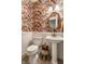 Charming powder room boasts a floral wallpaper, pedestal sink, and white wainscoting at 1020 Lair Ct, Westfield, IN 46074