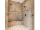 A luxurious tiled walk-in shower featuring dual shower heads, a built-in bench, and decorative mosaic tile at 1020 Lair Ct, Westfield, IN 46074