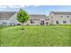 Expansive backyard with lush green lawn, a mature tree, and a patio area for outdoor entertaining at 10731 Jimmy Lake Dr, Indianapolis, IN 46239